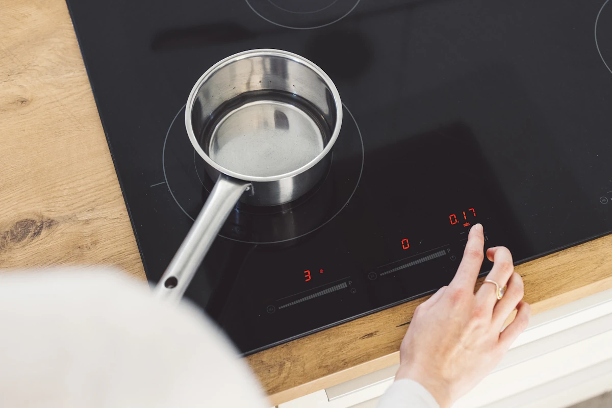 Une personne qui met en marche une plaque de cuisson