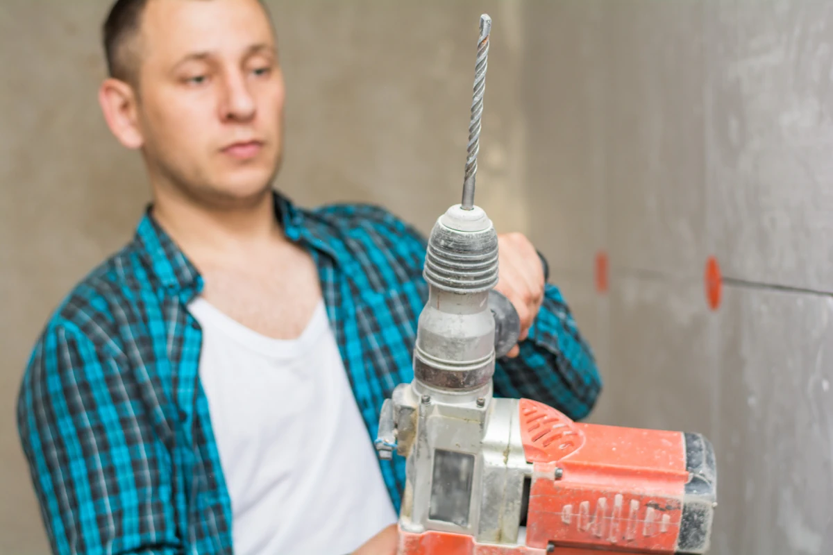 Un homme avec une perceuse pour beton