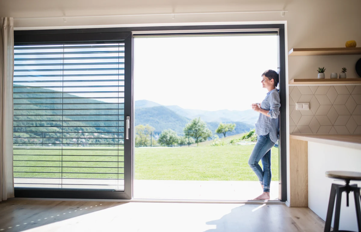 Une femme face à une porte coulissante ouverte