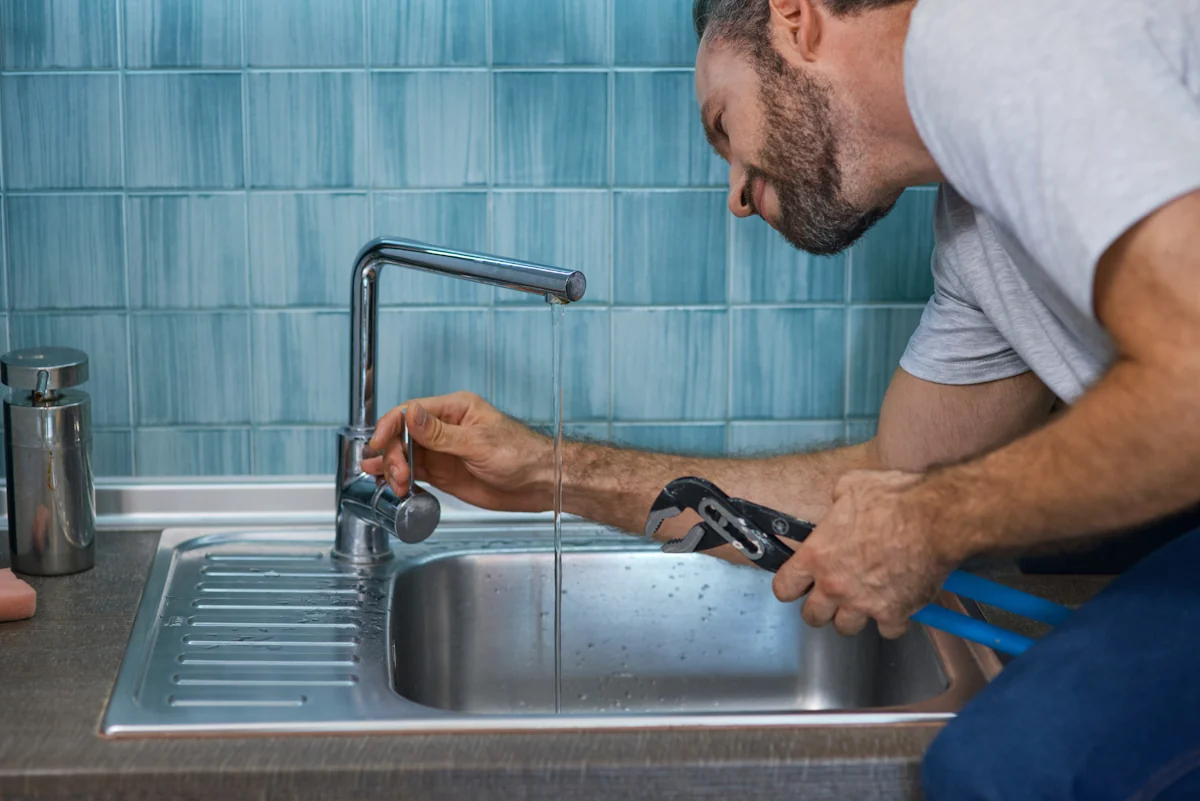 Un homme qui remplace un robinet d'arrivée d'eau