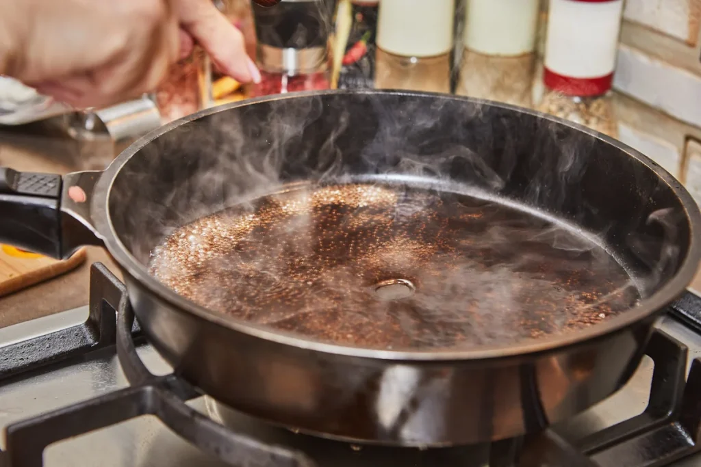 Une personne qui culotte une poêle en fonte