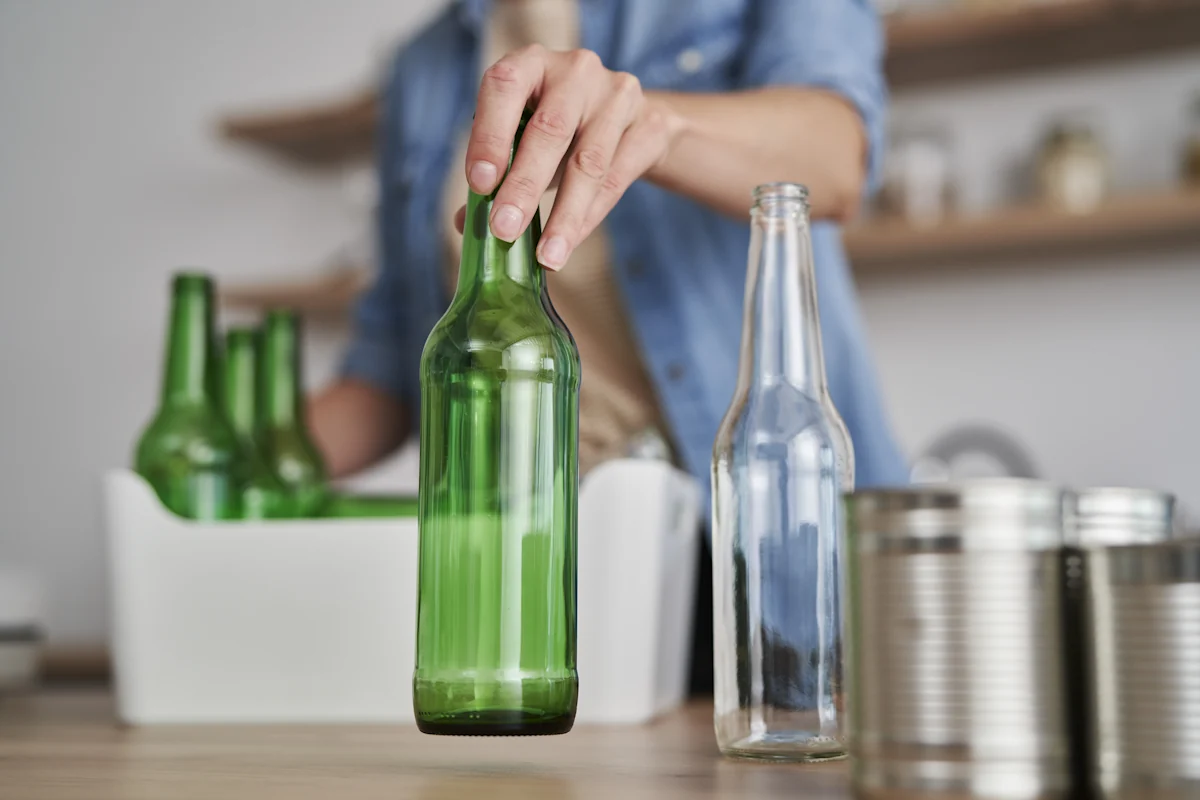 Une personne qui recycle bouteille en verre